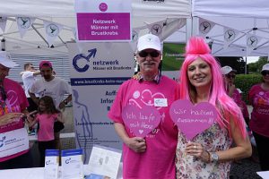 Ein Mann und eine Frau mit pinkfarbenen T-Shirts am Stand des Netzwerks Männer mit Brustkrebs