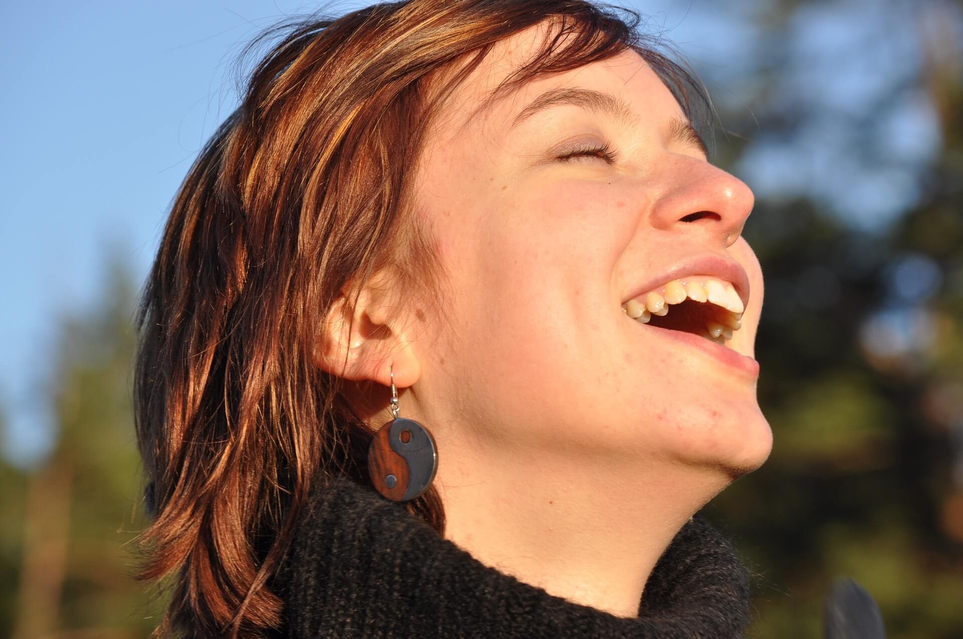 Frau mit kürzeren rotbraunen Haaren lacht